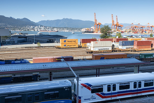 Vancouver, Canada - July 12,2022: View of trains and railroad tracks from Waterfront station in downtown Vancouver. North Vancouver in the background