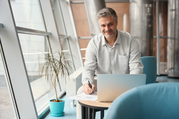 istock Man signs papers in a coworking space among plants 1436525151