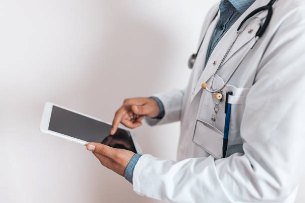 istock Unrecognizable doctor typing on digital tablet 1436529052