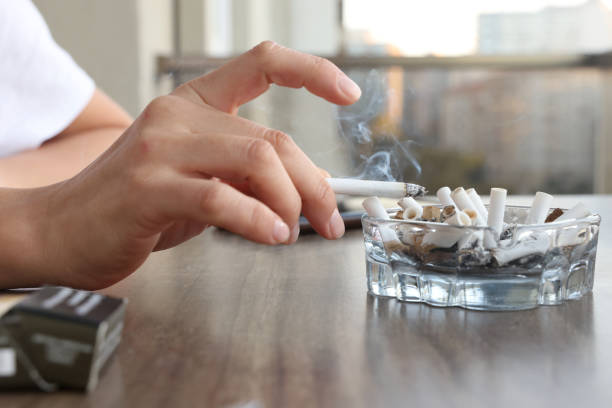 Woman holding on her fingers and ashtray​​​ foto