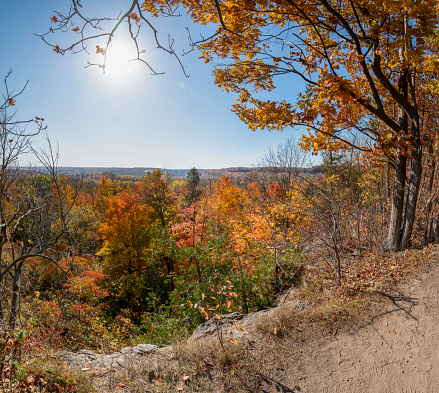The sun beams brightly over the Autumn coloured foliage around Milton, Ontario, as seen from Rattlesnake Point Conservation Area.