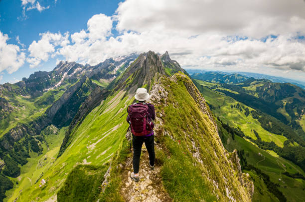 Alpstein portrait of female hiker at Altenalp Turm Portrait of a woman hiking the Swiss Alps with a awesome view of Altenalp Türm in the Appenzell area of Switzerland. Image taken with GoPro constricted stock pictures, royalty-free photos & images