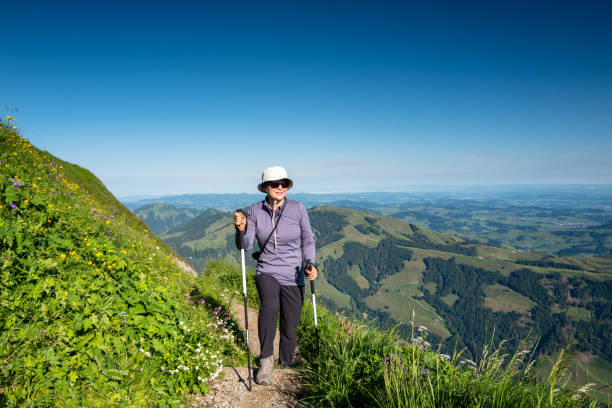 mujer mayor haciendo senderismo en altenalp tuerm, suiza - bastón de senderismo fotografías e imágenes de stock