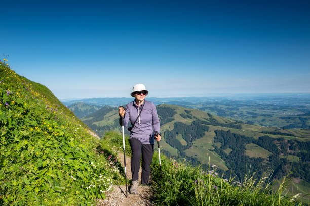 Senior woman hiking at Altenalp Tuerm, Switzerland Happy active senior woman hiking on Ebenalp trail in the Appenzellerland canton Switzerland appenzell innerrhoden stock pictures, royalty-free photos & images