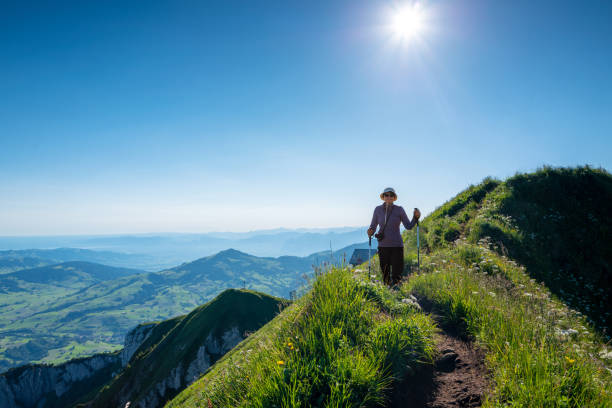 Senior woman hiking at Altenalp Tuerm, Switzerland Senior woman hiking on Ebenalp trail early morning in the Appenzellerland canton Switzerland appenzell innerrhoden stock pictures, royalty-free photos & images