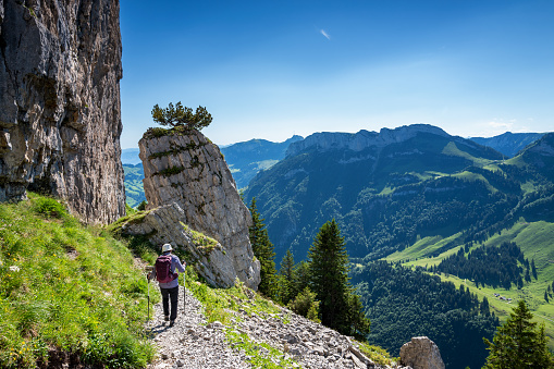 Rear view of active senior woman hiking on Ebenalp trail in the Appenzellerland canton Switzerland