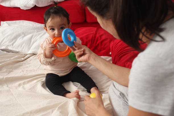 istock Baby girl playing with her mother 1436543625
