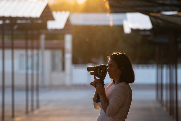 foto de una mujer adulta usando una cámara de video casera analógica - home video camera women videographer digital video camera fotografías e imágenes de stock