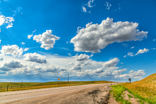 High puffy clouds above a rural landscape in central Wyoming on a warm summer afternoon.