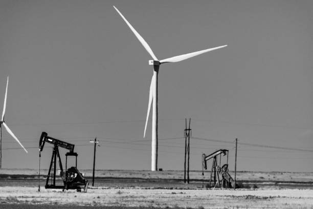 Wind turbines in a row, sky background, agricultural field, sustainable energy. Copy space available. Black and white view.