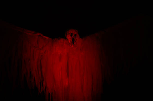 Halloween ghost decoration, scary red scream face costume installation in darkness