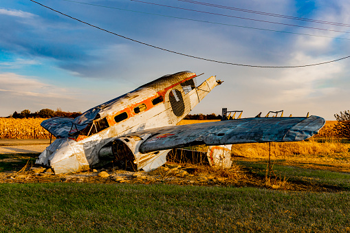 Norway, Illinois, United States - October 23, 2022: Agricultural Crash Monument: Beechcraft 18, a small, two-prop passenger plane, burrowed nose down into the ground, a partly smashed and gutted hulk, dedicated to all farmers and Ag related business folks that have lived thru Agricultural Crash of the 1980s, donated by Mervin and Phyllis Eastwold of Norwegian IMPL, Co. Tail number: N3657G.