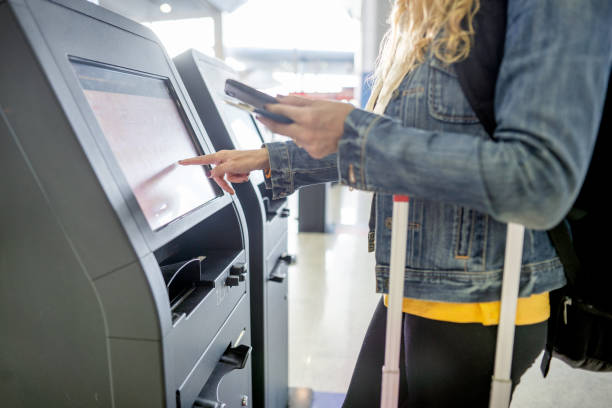 istock Female traveler using self check-in kiosk in airport 1436557301