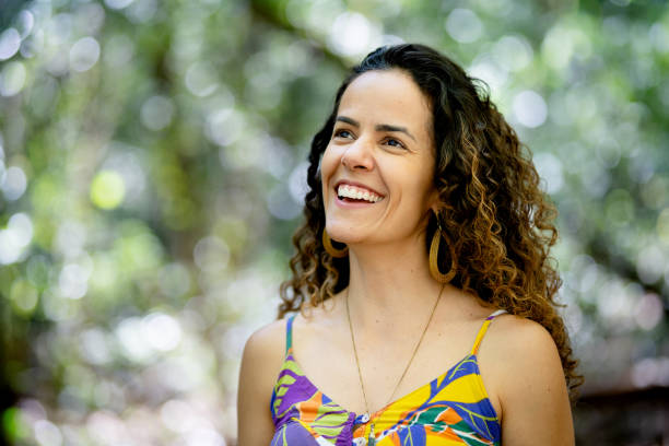 istock Young woman standing alone outside in a forest and smiling 1436558301