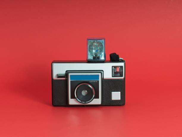 istock Vintage roll film camera with flash cube centered on a red background 1436559746