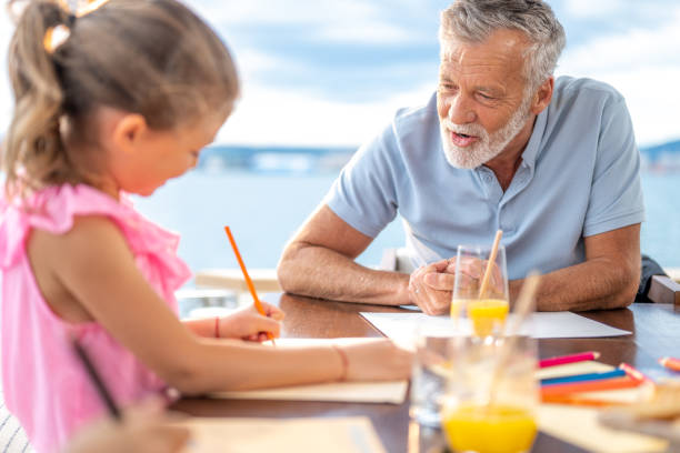 istock Mature man watching his granddaughter while drawing picture 1436562633