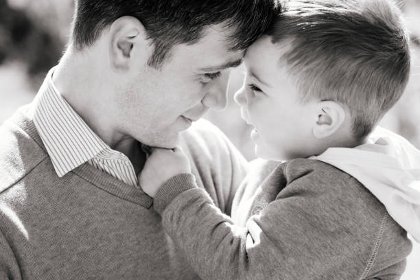 istock A young father with a three-year-old son are hugging and smiling outdoors, black and white. The concept of raising a happy child 1436562668
