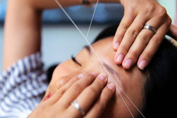 istock eyebrow waxing with threading on a young woman 1436563338