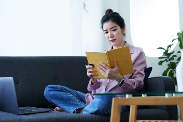 istock Portrait of a self-employed Asian woman holding a notebook and using a computer doing video conference at home 1436563579