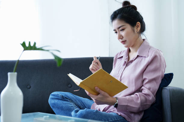 istock Portrait of a self-employed Asian woman holding a notebook and using a computer doing video conference at home 1436563746