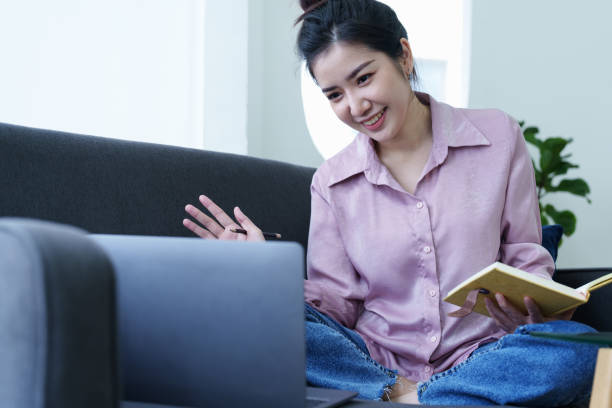 istock Portrait of a self-employed Asian woman holding a notebook and using a computer doing video conference at home 1436563838