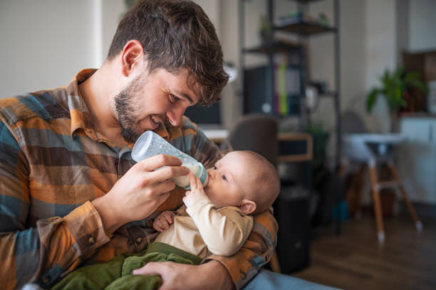 istock Caring father feeding his baby son with bottle. 1436564171