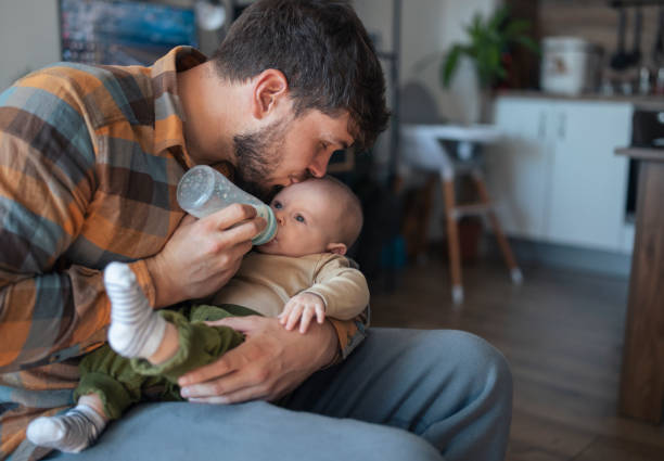 istock Caring father feeding his baby son with bottle. 1436564172