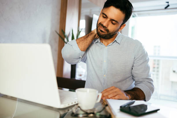 istock Man with neck pain using laptop working from home 1436566435