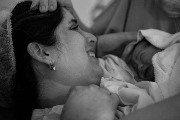 Mother holding her newborn baby child after labor in a hospital stock photo