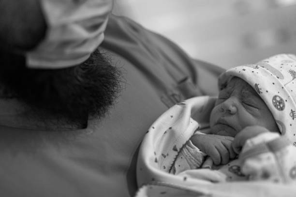 Father holdng his newborn baby after witnessing the birth and neonatal examination. Buenos Aires. Argentina. Latin America.