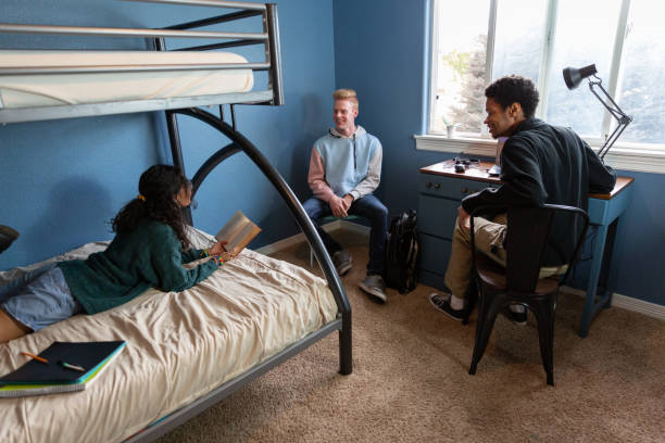 istock College students in a dorm room studying and hanging out. 1436577047