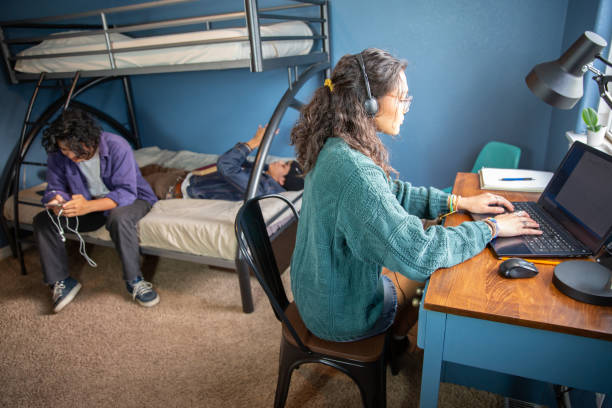 istock College students in a dorm room studying and hanging out. 1436577418