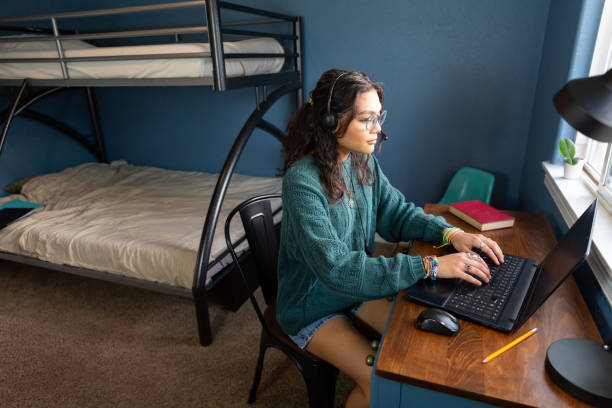 istock College students in a dorm room studying and hanging out. 1436577627
