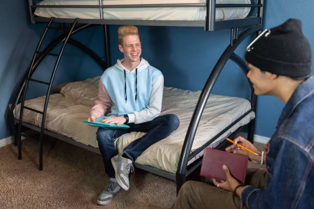 istock College students in a dorm room studying and hanging out. 1436578295