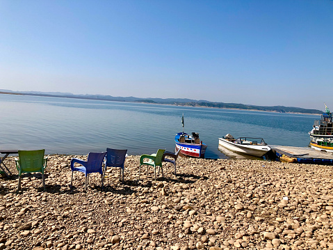 Boats parked at jetty in stone filled area