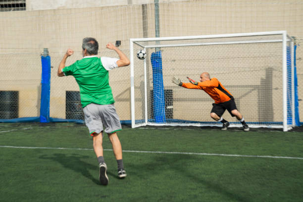 istock Male soccer player celebrating after scoring a goal during match 1436584147