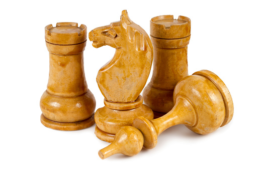 Wooden chess pieces on a white background. Old handmade chess.