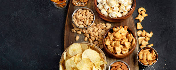 istock Assortment of salty snacks on dark background. 1436596477