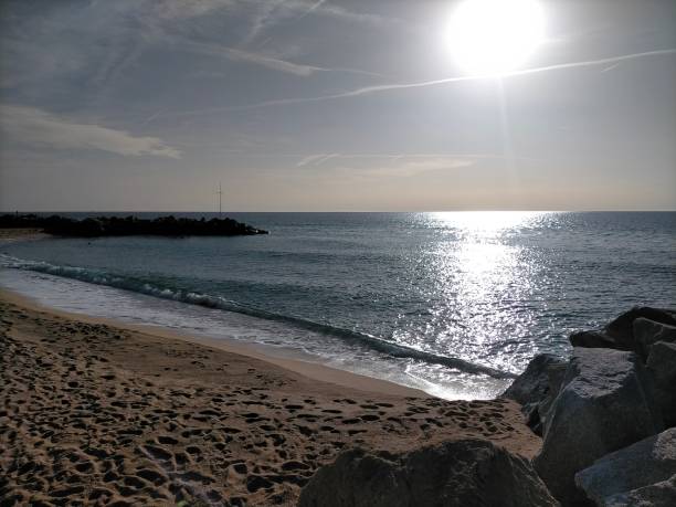 vilassar de mar strandszene mit der frühen morgensonne und der reflexion des sonnenlichts auf dem ruhigen meer. - horizontal landscape coastline gujarat stock-fotos und bilder