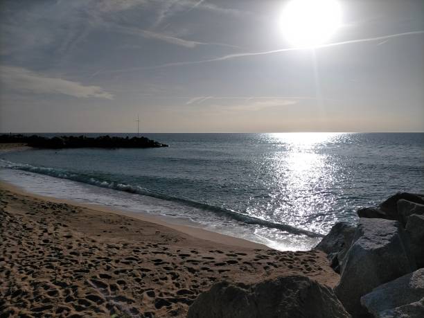 пляжная сцена вилассар-де-мар с ранним утренним солнцем и отражением солнечного света на спокойном море. - horizontal landscape coastline gujarat стоковые фото и изображения