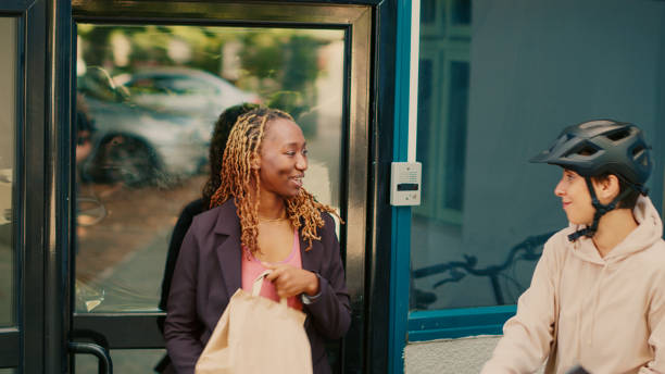 istock Female carrier giving fastfood package order 1436603887