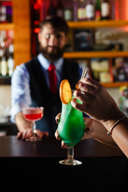 Bartender serve cocktail drink for customer at the bar