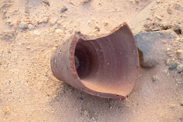 壊れた粘土の花瓶が砂の上に横たわっている - terra cotta pot ストックフォトと画像
