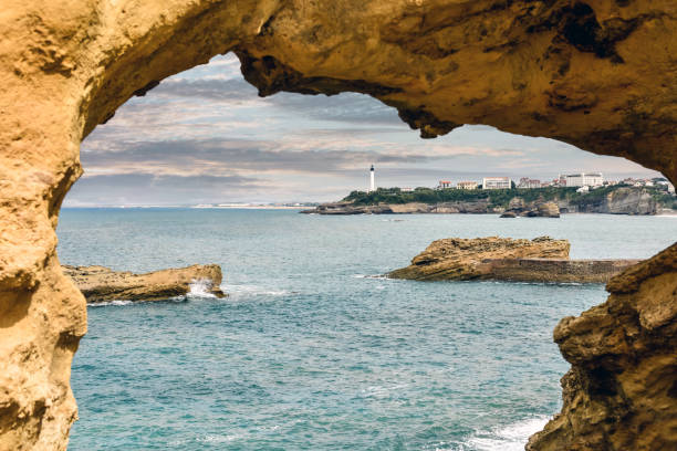 schöne küstenlandschaft von biarritz mit seinem berühmten leuchtturm bei sonnenuntergang - rocher de la vierge stock-fotos und bilder