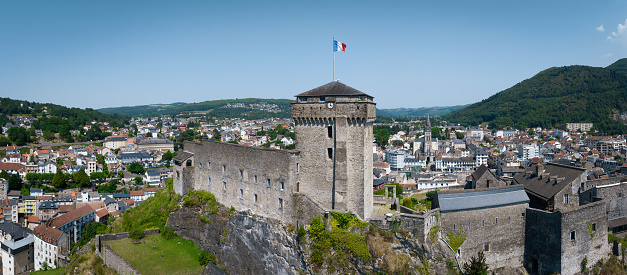 Lourdes, France - July 18, 2022: Lourdes City Panorama in Summer with Château fort de Lourdes Fort Drone XXL City Panorama. Lourdes is a  World famous Pilgrim destination., a small market town lying in the foothills of the Pyrenees, famous for the Maria apparitions of Our Lady of Lourdes. Château fort de Lourdes, Lourdes, Lourdes,  Hautes-Pyrenees, France, Europe