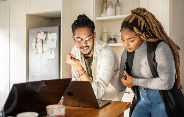 istock Two young colleagues working on a laptop in their startup's kitchen 1436624768