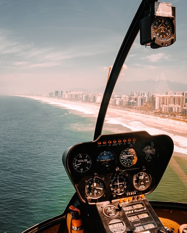 Rio de Janeiro, Brazil – April 05, 2022: A vertical shot of a helicopter cockpit overlooking the beach