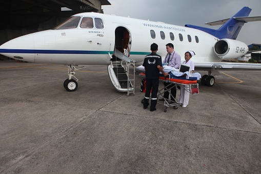 Dhaka, Bangladesh – September 04, 2022: The medical team transfers a patient from an ambulance to a waiting air ambulance