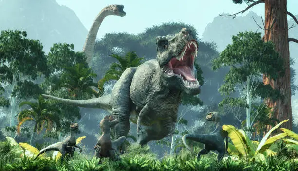 Photo of Tyrannosaurus and velociraptor walking through the forest.