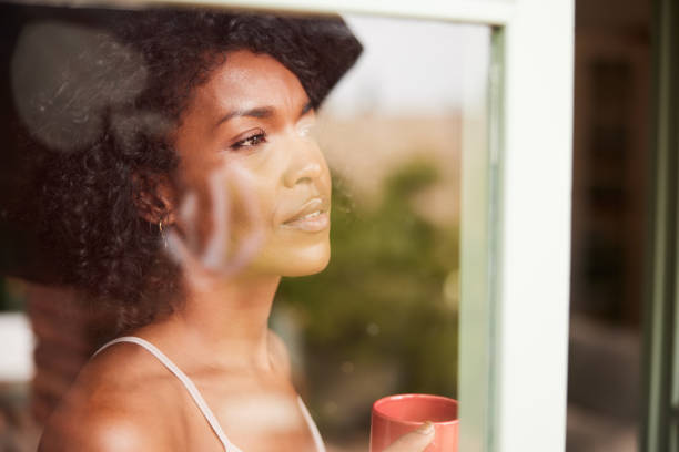 istock Beautiful content dark-skinned multi-ethnic woman daydreaming through the window 1436629041